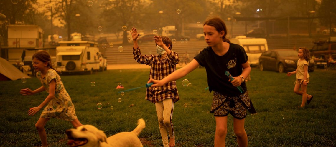 Children play at the showgrounds in the southern New South Wales town of Bega where they are camping after being evacuated from nearby sites affected by bushfires on December 31, 2019. - Thousands of holidaymakers and locals were forced to flee to beaches in fire-ravaged southeast Australia on December 31, as blazes ripped through popular tourist areas leaving no escape by land. (Photo by SEAN DAVEY / AFP) (Photo by SEAN DAVEY/AFP via Getty Images)