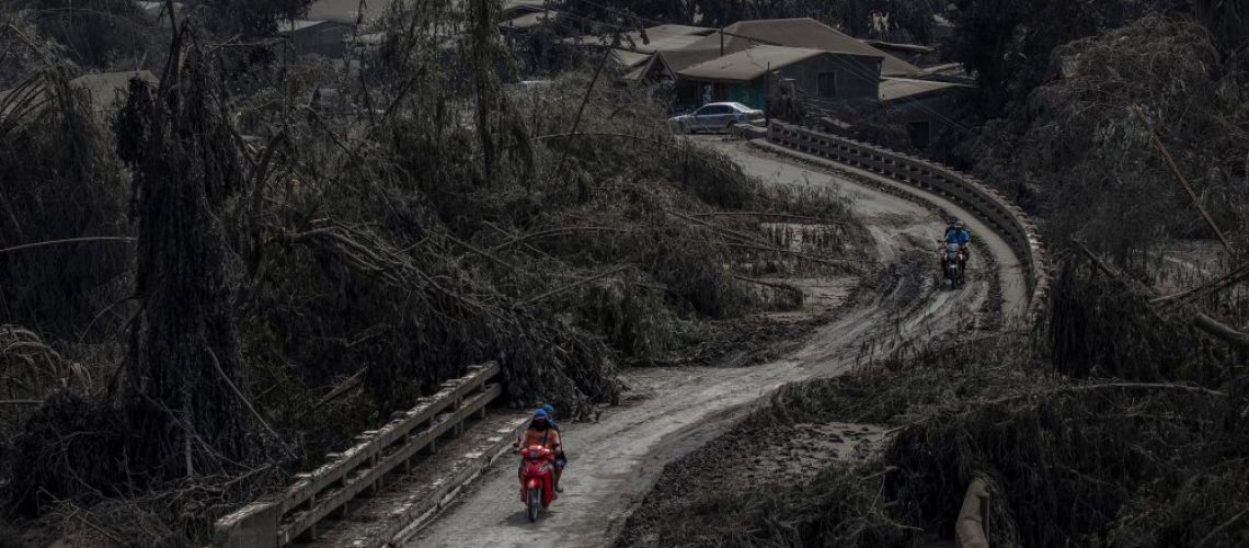 LAUREL, PHILIPPINES - JANUARY 14: Motorists cross a bridge partially blocked by trees fallen by volcanic ash from Taal Volcano's eruption on January 14, 2020 in Laurel, Batangas province, Philippines. The Philippine Institute of Volcanology and Seismology raised the alert level to four out of five, warning that a hazardous eruption could take place anytime, as authorities have evacuated tens of thousands of people from the area. An estimated $10 million worth of crops and livestock have been damaged by the on-going eruption, according to the country's agriculture department. (Photo by Ezra Acayan/Getty Images)